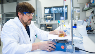 Ein Wissenschaftler arbeitet an einem Versuchsaufbau im Labor.