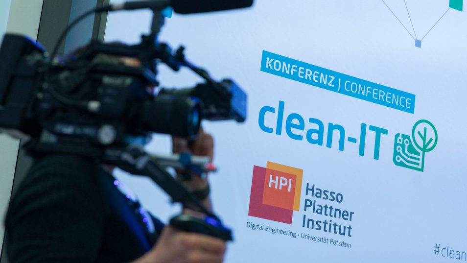 Camera operator in front of screen display conference logo "Clean IT" by HPI