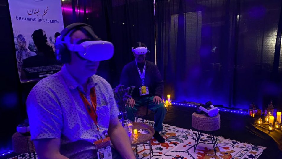 Jan Lüdert sitting on chair wearing headphones and VR googles experiencing the VR documentary 